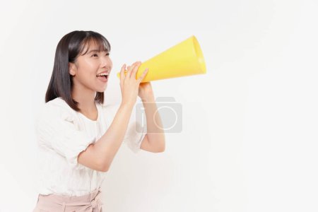 Photo for Young Japanese woman posing with yellow cheer horn on white background - Royalty Free Image