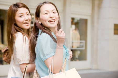 Téléchargez les photos : Deux femmes asiatiques avec des sacs marchant au centre commercial - en image libre de droit