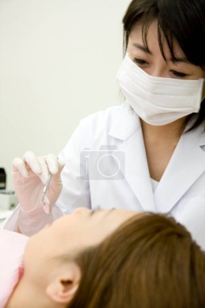 Photo for Young japanese woman and dentist in dental clinic - Royalty Free Image