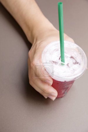 Téléchargez les photos : Main de femme tenant une tasse avec boisson froide - en image libre de droit