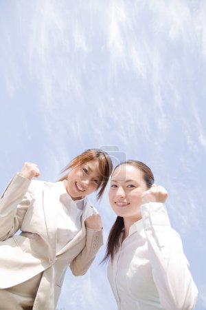 Foto de Joven asiático negocios mujeres mostrando puños al aire libre - Imagen libre de derechos