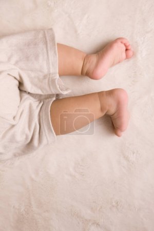 Foto de Foto recortada de piernas de bebé en manta blanca - Imagen libre de derechos