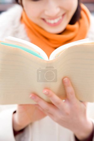 Foto de Mujer joven leyendo un libro en la calle - Imagen libre de derechos