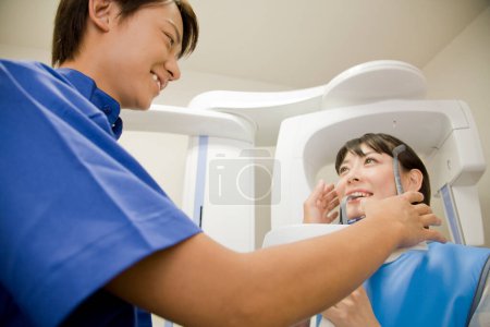 Téléchargez les photos : Jeune femme asiatique se prépare à faire des rayons X de ses dents - en image libre de droit