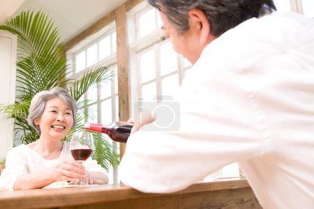 Photo for Happy asian couple drinking wine at home - Royalty Free Image