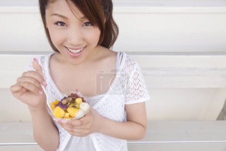 Photo for Portrait of beautiful young japanese woman eating ice cream during summer vacation - Royalty Free Image