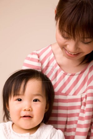 Téléchargez les photos : Portrait de mère asiatique et sa petite fille souriante - en image libre de droit