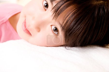 Téléchargez les photos : Portrait de asiatique petite fille couché sur lit - en image libre de droit
