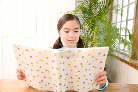 Téléchargez les photos : Fermer petit asiatique fille lecture un livre - en image libre de droit