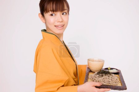 Foto de Asiático mujer camarera en tradicional kimono servir comida - Imagen libre de derechos