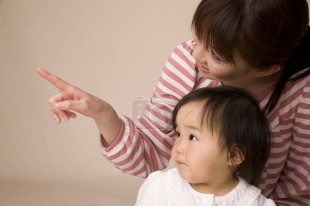 Photo for Asian mother showing something to her little daughter - Royalty Free Image