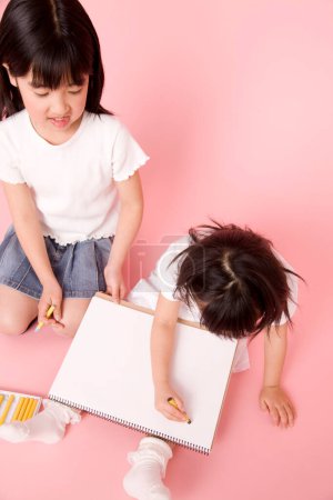 Photo for Cute little asian children drawing on pink background - Royalty Free Image