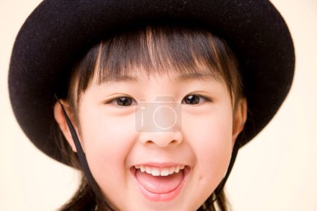 Téléchargez les photos : Portrait de asiatique petite fille en chapeau noir - en image libre de droit