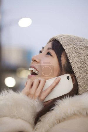 Foto de Retrato de mujer asiática en ropa de invierno con teléfono móvil - Imagen libre de derechos