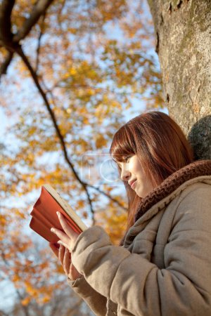 Foto de Mujer con libro en bosque de otoño - Imagen libre de derechos