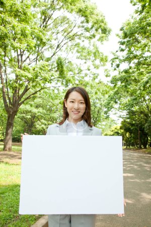 Photo for Portrait of young Japanese businesswoman on nature during sunny day - Royalty Free Image