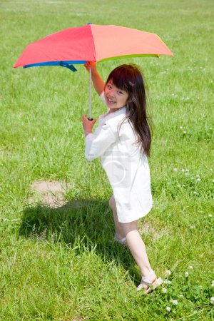 Photo for Child with an umbrella in rainbow colours - Royalty Free Image