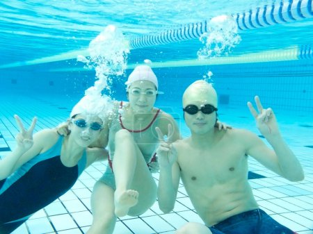 Foto de Foto submarina de amigos nadando en la piscina - Imagen libre de derechos