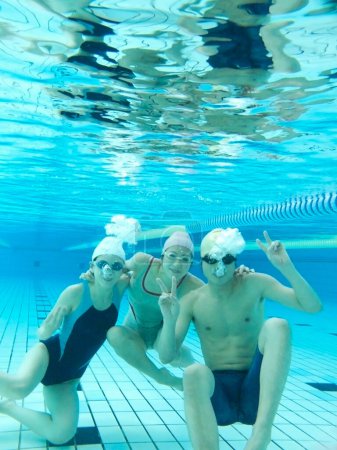 Photo for Underwater photo of friends swimming in pool - Royalty Free Image