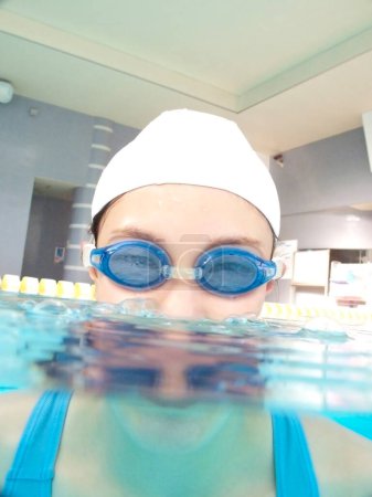 Téléchargez les photos : Asiatique fille natation et plongée à la piscine - en image libre de droit