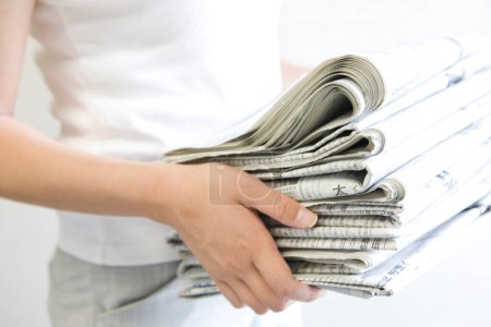 Téléchargez les photos : Hands holding stack of newspapers - en image libre de droit