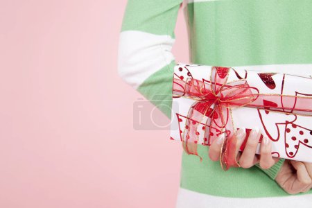 Photo for Young Japanese woman holding gift box, portrait on pink studio background - Royalty Free Image