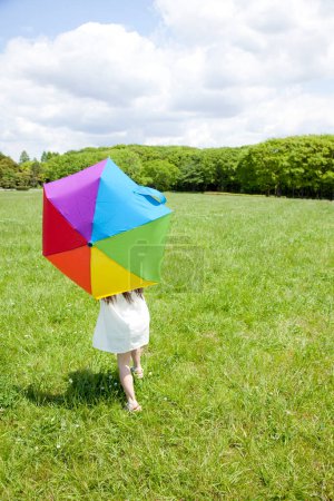 Foto de Niño con un paraguas en colores arcoíris - Imagen libre de derechos