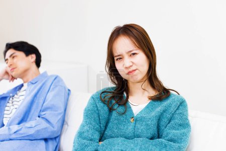 Foto de Joven pareja japonesa sentado en sofá en casa y no hablar entre sí después de la discusión - Imagen libre de derechos