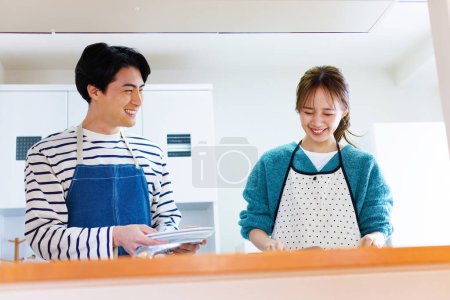 Téléchargez les photos : Couple préparant une salade de légumes frais dans la cuisine - en image libre de droit