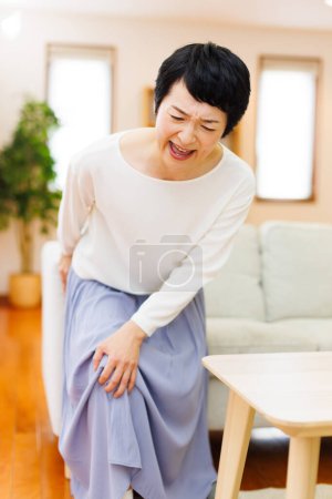 Photo for Asian woman suffering from pain in her knee - Royalty Free Image