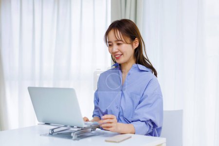 Young Japanese woman working at home. Remote working concept