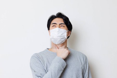 Photo for Sick young asian man wearing protective mask - Royalty Free Image