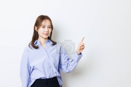 Téléchargez les photos : Jeune femme pointant quelque chose sur un fond blanc
. - en image libre de droit