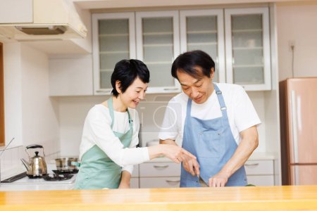 Photo for Middle aged asian man and woman cooking together - Royalty Free Image