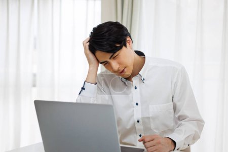 Foto de Estresado asiático hombre de negocios en el trabajo con ordenador portátil en la oficina. - Imagen libre de derechos