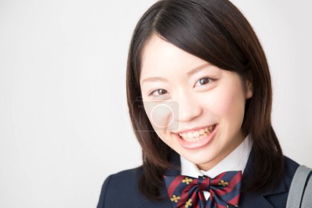 Téléchargez les photos : Portrait studio d "écolière japonaise souriante en uniforme - en image libre de droit
