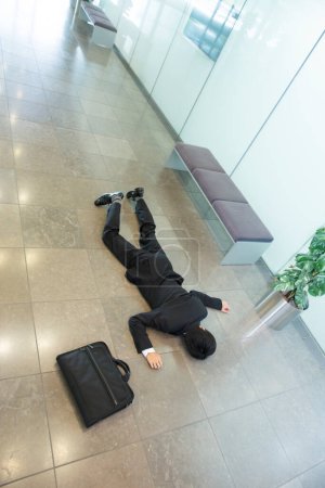 Foto de Hombre de negocios en traje tendido en el suelo en la oficina. - Imagen libre de derechos