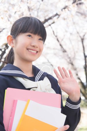 Photo for Portrait of beautiful Japanese student with books on street waving - Royalty Free Image