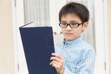 Photo for Asian boy reading a book - Royalty Free Image