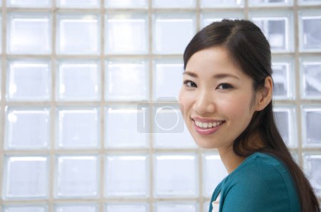 Photo for Portrait of young asian  woman standing by window - Royalty Free Image
