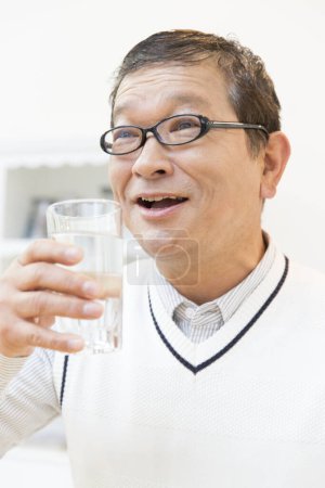 Téléchargez les photos : Portrait de l'homme asiatique tenant verre d'eau dans sa main, concept de mode de vie sain - en image libre de droit