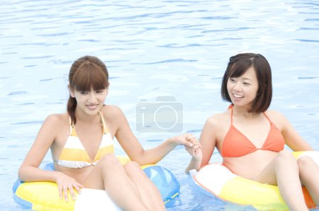Foto de Hermosas mujeres japonesas en trajes de baño coloridos que se divierten en la piscina, concepto de vacaciones - Imagen libre de derechos