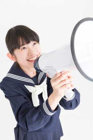 Photo for Young asian schoolgirl with megaphone on white background - Royalty Free Image