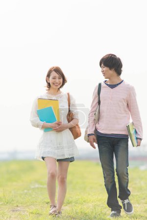 Téléchargez les photos : Couple de jeunes étudiants japonais heureux passer du temps ensemble sur la nature - en image libre de droit