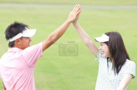 Photo for A man and a woman giving each other a high five - Royalty Free Image
