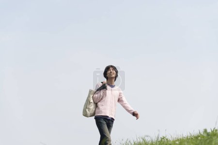 Photo for Young man walking  on the field - Royalty Free Image