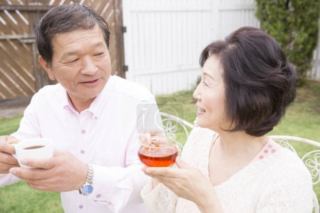 Foto de Feliz asiático pareja bebiendo té al aire libre - Imagen libre de derechos