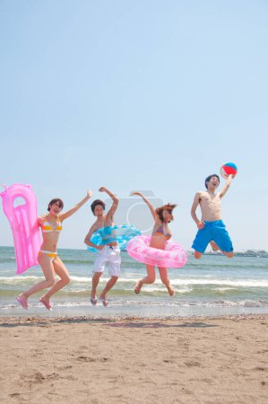 glücklich asiatische Freunde springen auf die Strand