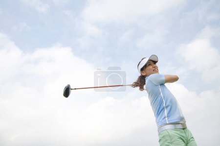 Téléchargez les photos : Jeune golfeuse jouant au golf sur le terrain de golf - en image libre de droit