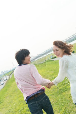 Téléchargez les photos : Heureux jeune couple asiatique courir dans le parc d'été - en image libre de droit